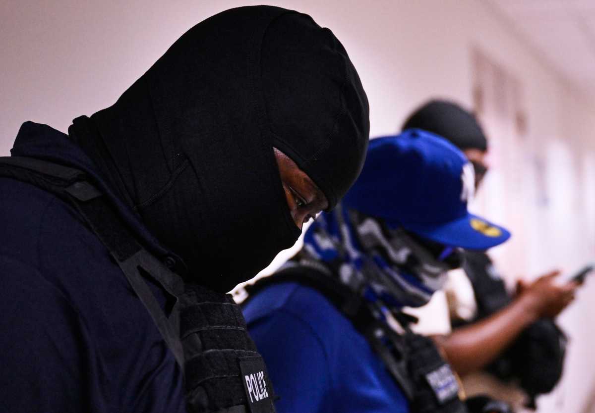 ICE agents wearing masks line the halls of the 12th floor at 26 Federal Plaza in Manhattan on Friday. The agents remained stationed outside immigration courtrooms, where multiple individuals were detained following their hearings